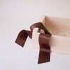 Brown ribbon on a beige fabric background