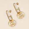 Gold earrings with geometric design on a beige background